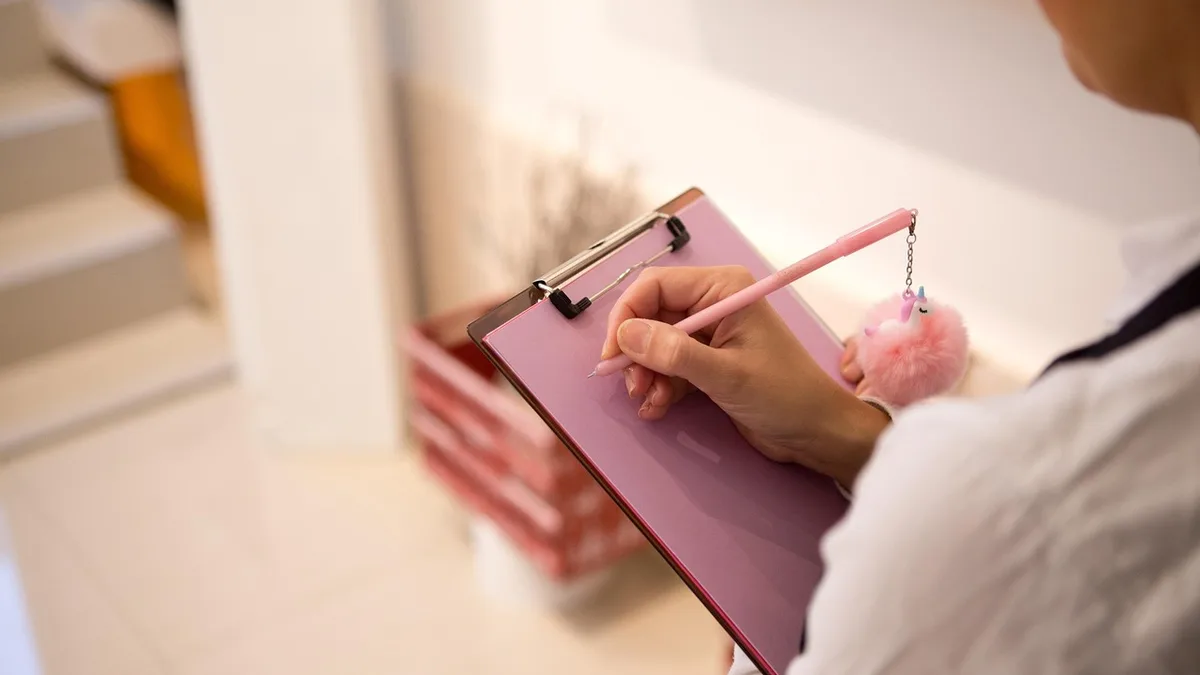 Restaurant manager counting stock with a clipboard in a supply storeroom