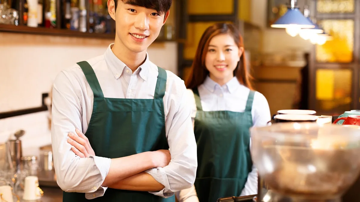 Restaurant staff working together and smiling behind the counter