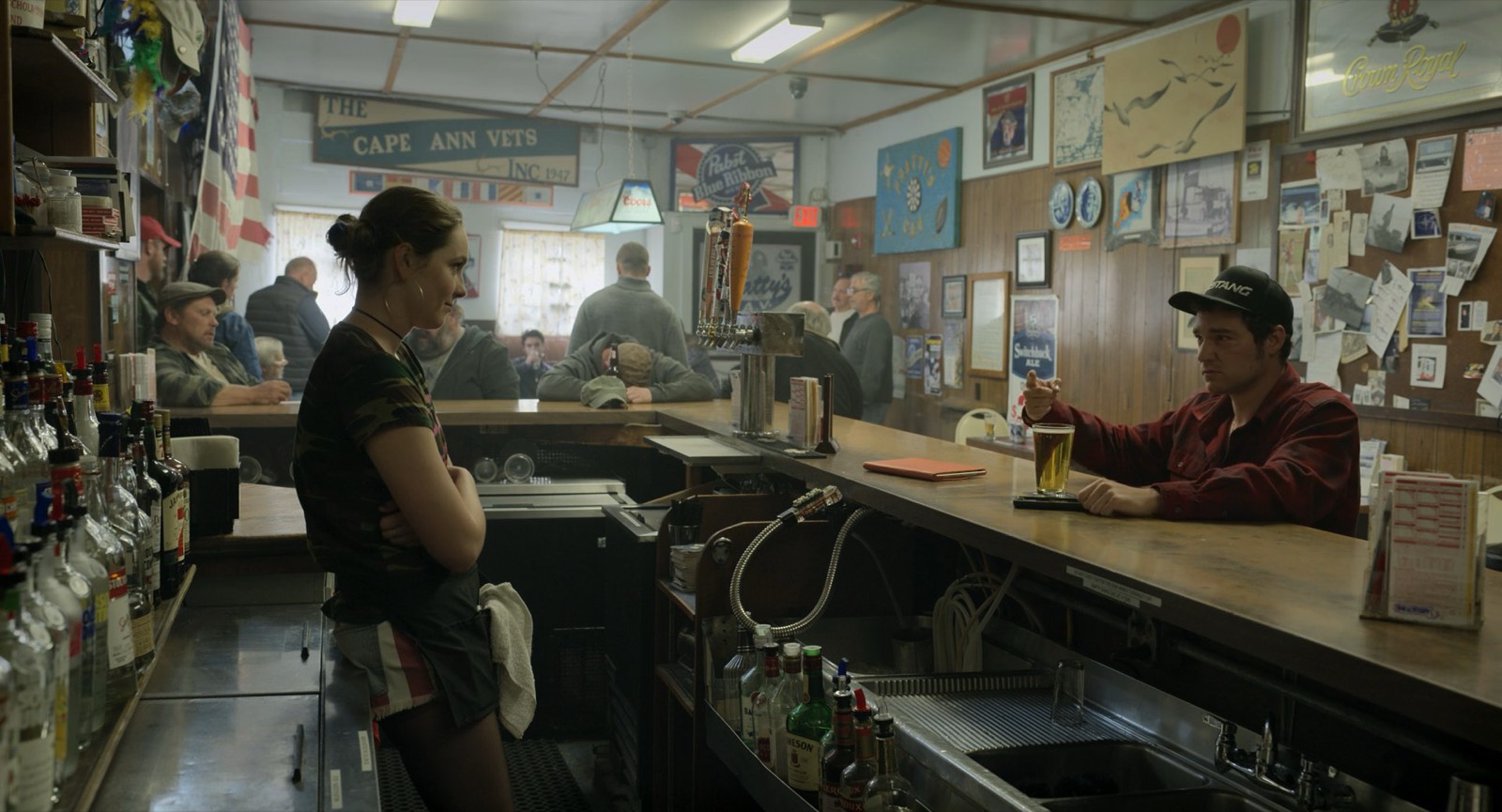 A bartender working the counter of a busy neighborhood bar.